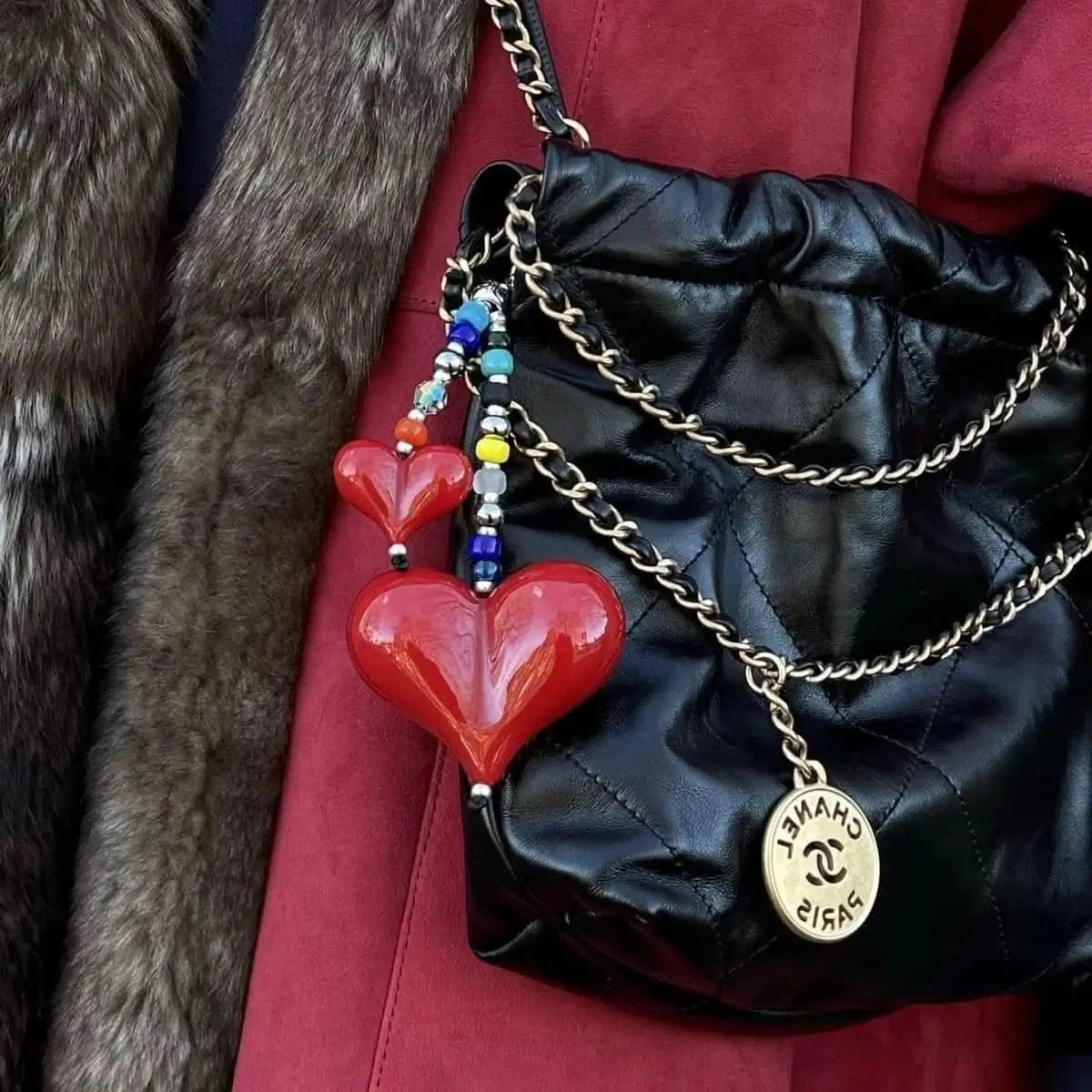 Big Love Shorty Bag Charm styled on a classic Chanel handbag, showcasing its chic design and the contrast between the vibrant beads and the bag's texture.