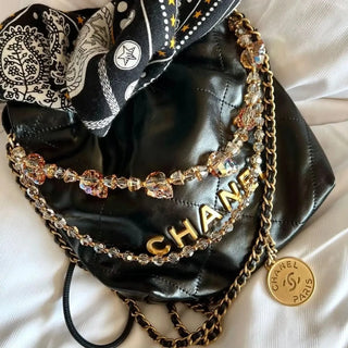 Big F*cking Skulls Bag Ting² elegantly draped over the handle of a luxury handbag, adding a bold and edgy accent to the accessory.