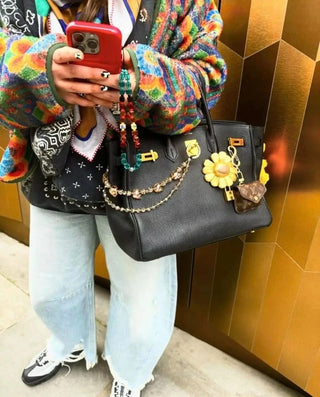 The Big F*cking Skulls Bag Ting² styled on a designer bag, highlighting the shimmering Swarovski skulls and detailed beadwork.