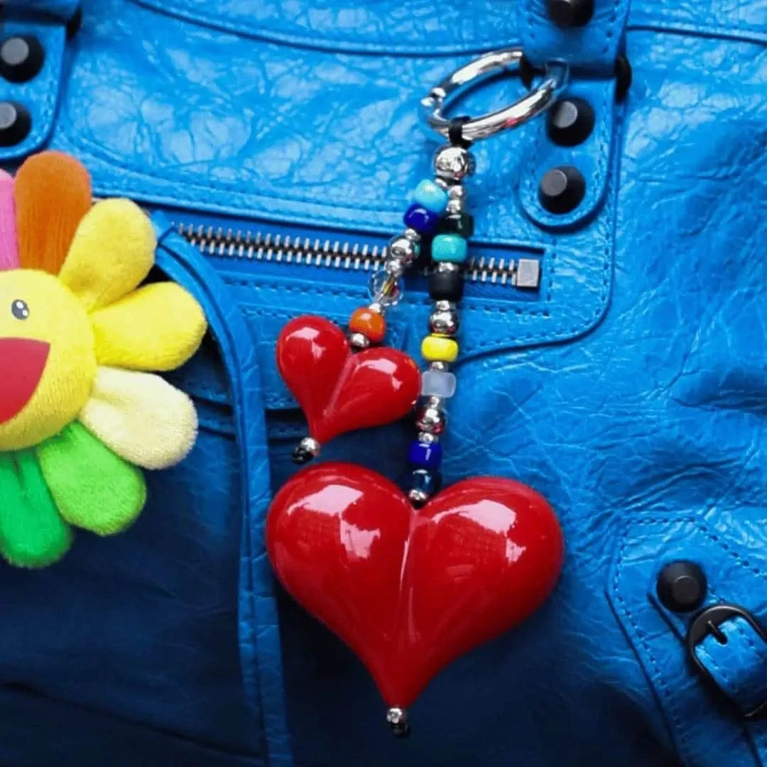 Big Love Shorty Bag Charm styled on a luxury Balenciaga handbag, adding a bold and elegant accent with its red resin hearts and sparkling beads.