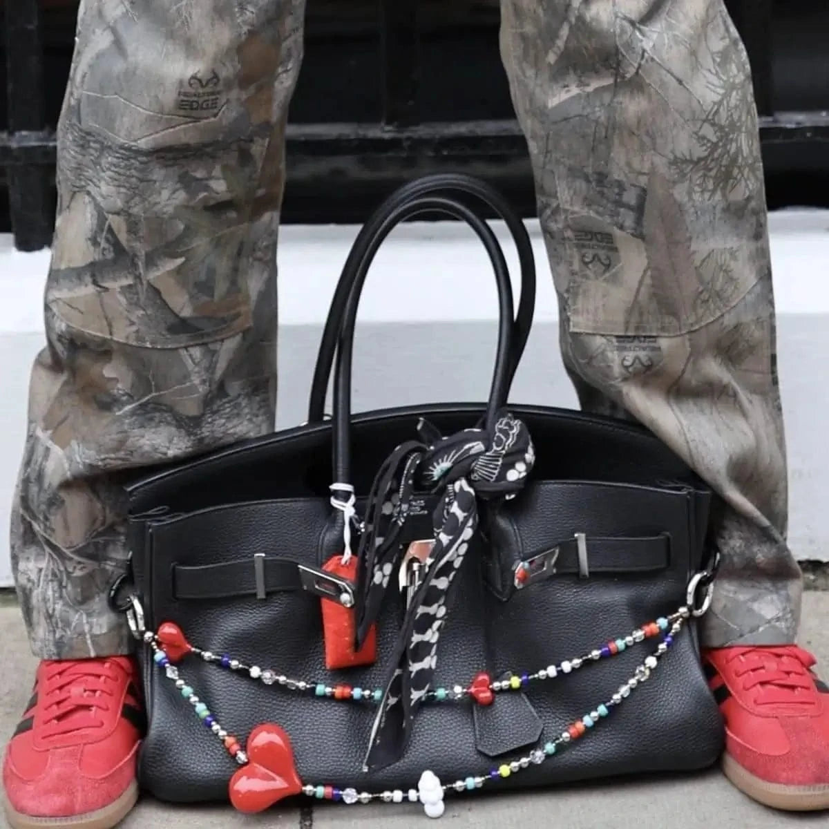 Big Love² Bag Charm styled on a luxury Birkin handbag, adding a bold and elegant accent with its red resin hearts and sparkling beads.